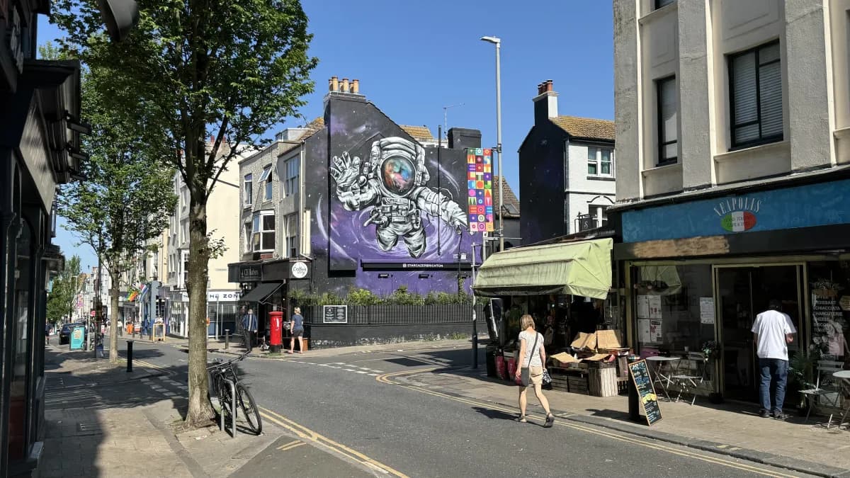 A large purple wall mural of an astronaut on a building off St James's Street, Kemptown
