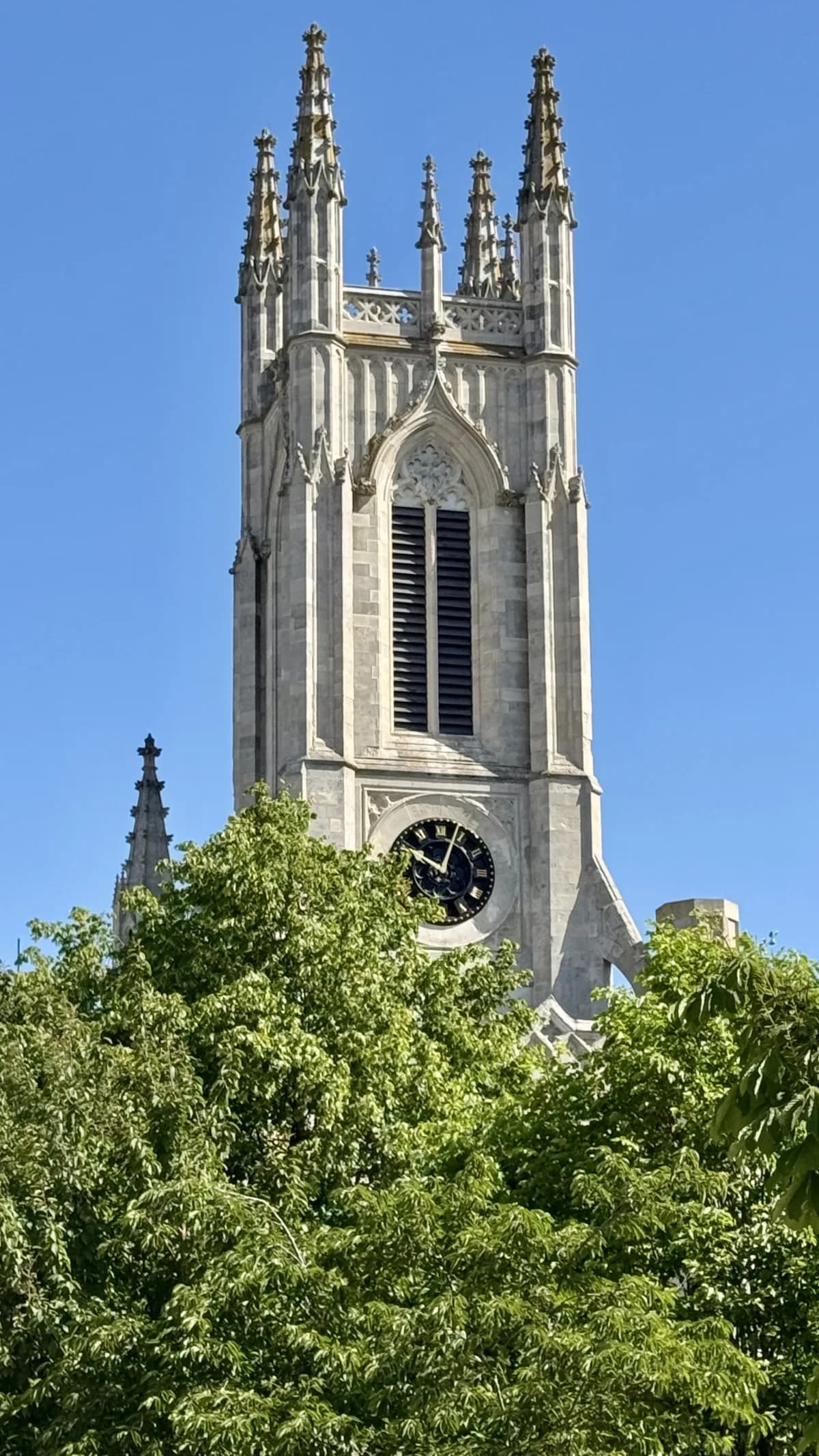 The gothic stone spire of St Peter's Church Brighton against a blue sky