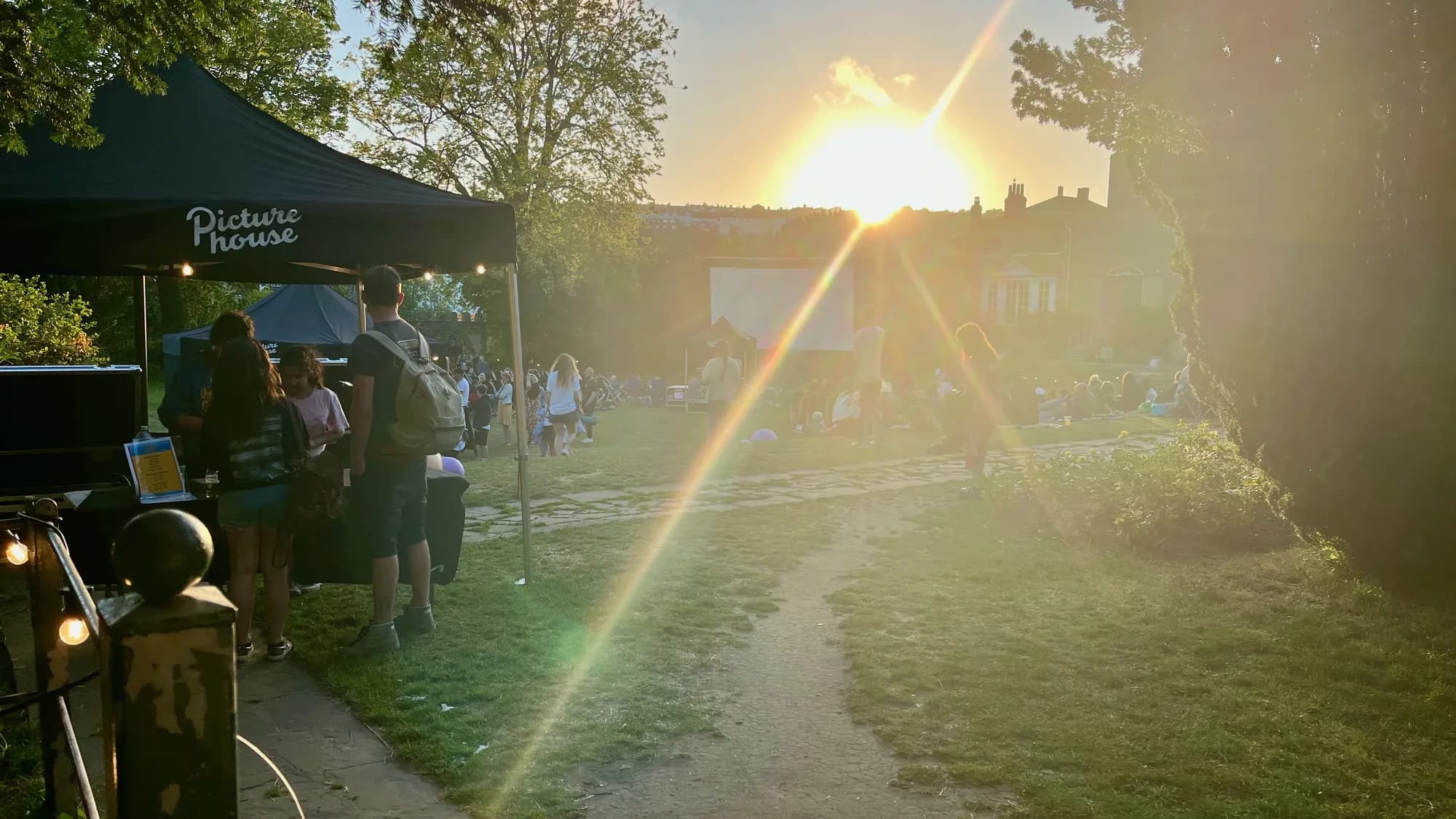 The Picturehouse outdoor cinema set up in Preston Park at sunset with the audience gathering