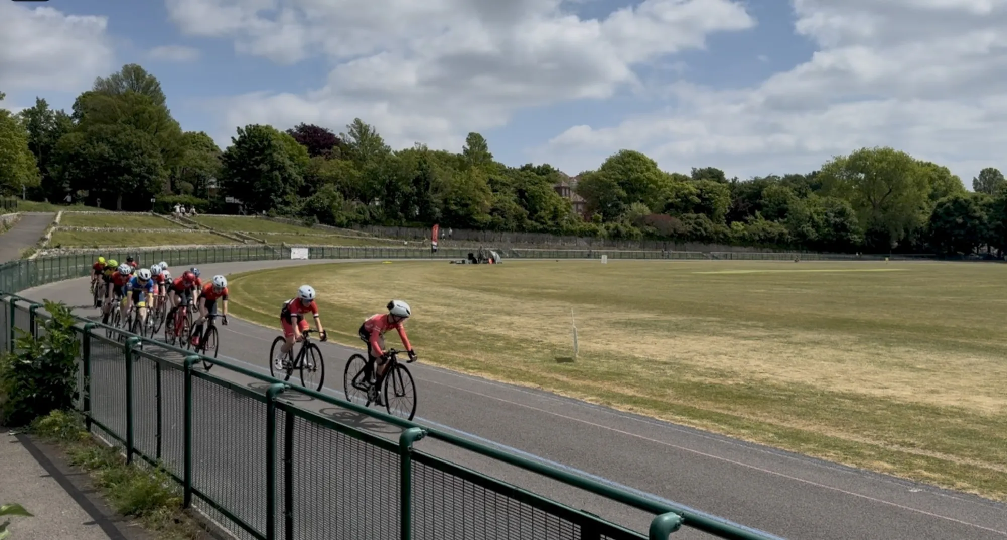 Cyclists racing around the Preston Park velodrome on a summer afternoon